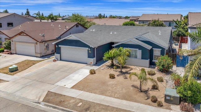3673 N Denali Ave, Fresno, CA 93727 - ranch-style house with an attached garage, concrete driveway, a residential view, stucco siding, and a shingled roof