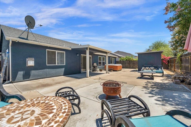 3673 N Denali Ave, Fresno, CA 93727 - rear view of house featuring a hot tub, a fire pit, a fenced backyard, and a patio