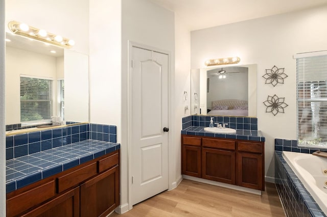 10223 N Price Ave, Fresno, CA 93730 - ensuite bathroom with wood finished floors, a whirlpool tub, vanity, ceiling fan, and backsplash