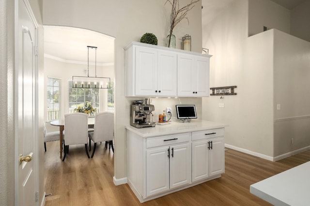 10223 N Price Ave, Fresno, CA 93730 - kitchen with light wood-style flooring, white cabinets, light countertops, ornamental molding, and a chandelier