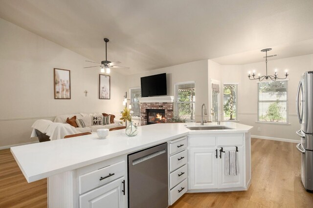 10223 N Price Ave, Fresno, CA 93730 - kitchen with appliances with stainless steel finishes, open floor plan, light wood-style flooring, a brick fireplace, and ceiling fan