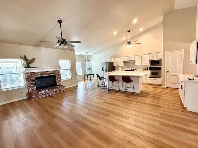 10223 N Price Ave, Fresno, CA 93730 - kitchen with appliances with stainless steel finishes, a ceiling fan, open floor plan, a center island with sink, and high vaulted ceiling