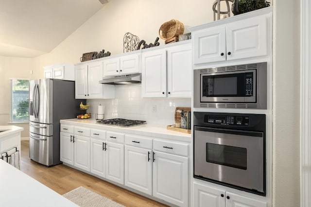 10223 N Price Ave, Fresno, CA 93730 - kitchen featuring appliances with stainless steel finishes, under cabinet range hood, lofted ceiling, backsplash, and light wood finished floors