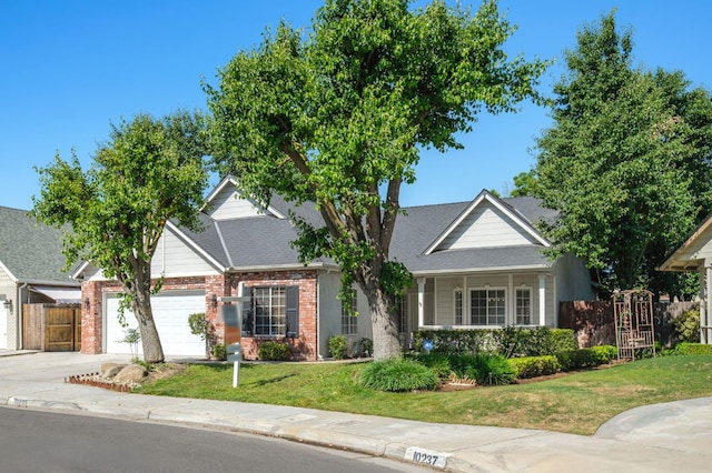 10223 N Price Ave, Fresno, CA 93730 - view of front of home featuring a garage, brick siding, and driveway