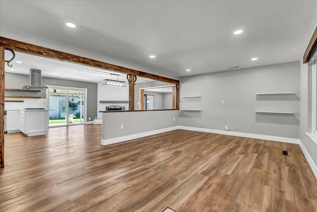 1408 S Hope Ave, Reedley, CA 93654 - unfurnished living room featuring wood finished floors, recessed lighting, and beamed ceiling