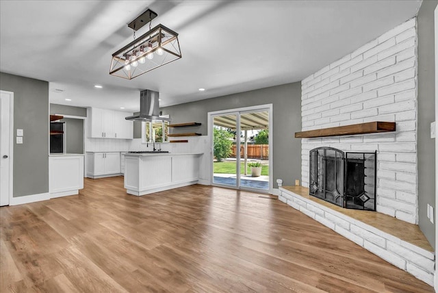 1408 S Hope Ave, Reedley, CA 93654 - unfurnished living room with light wood-type flooring, recessed lighting, and a fireplace