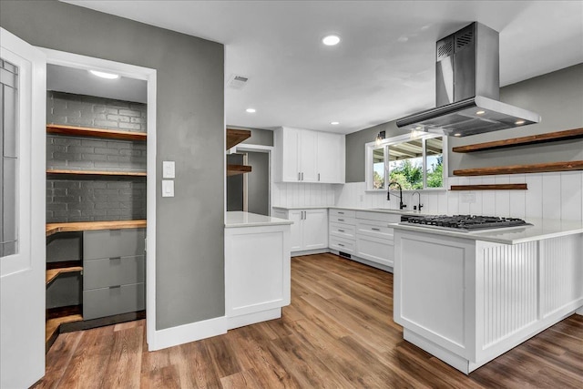 1408 S Hope Ave, Reedley, CA 93654 - kitchen with exhaust hood, stainless steel gas stovetop, open shelves, white cabinetry, and backsplash