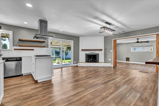1408 S Hope Ave, Reedley, CA 93654 - kitchen with open floor plan, appliances with stainless steel finishes, island exhaust hood, white cabinetry, and wood finished floors