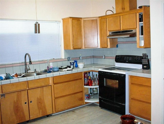 34937 Bronco Ln, Yokuts Valley, CA 93675 - kitchen with range with electric stovetop, under cabinet range hood, light wood-type flooring, backsplash, and tile countertops