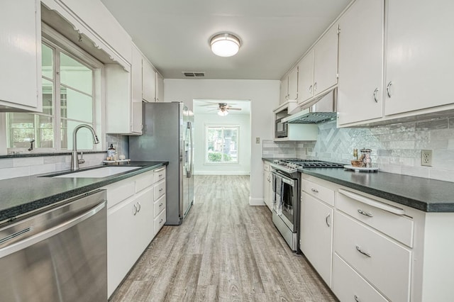 927 W Pico Ave, Fresno, CA 93705 - kitchen featuring appliances with stainless steel finishes, dark countertops, light wood-type flooring, and backsplash
