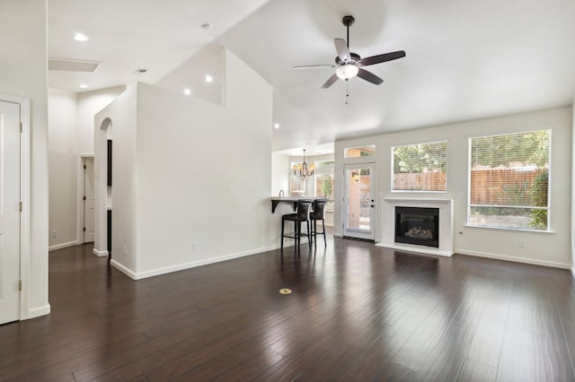 1158 E Hogan Ave, Fresno, CA 93730 - living area featuring a glass covered fireplace, a ceiling fan, wood finished floors, high vaulted ceiling, and a chandelier