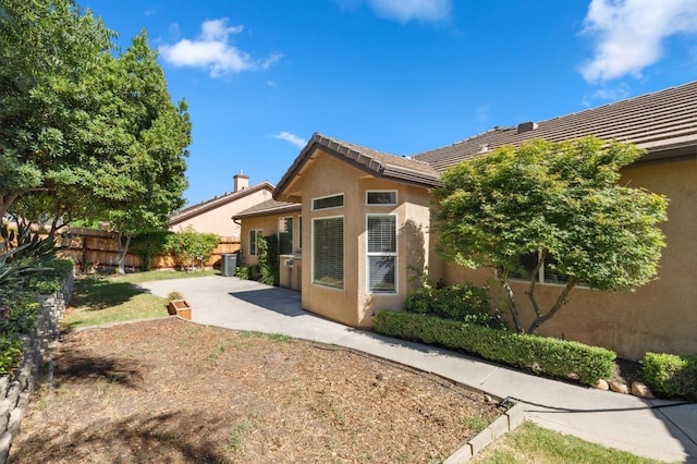 1158 E Hogan Ave, Fresno, CA 93730 - back of property with stucco siding, a patio, and a tile roof