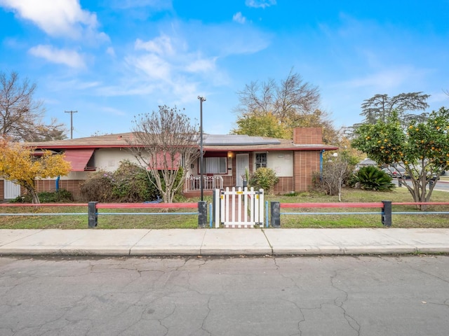 3110 N Del Mar Ave, Fresno, CA 93704 - single story home featuring a fenced front yard, solar panels, a gate, and covered porch