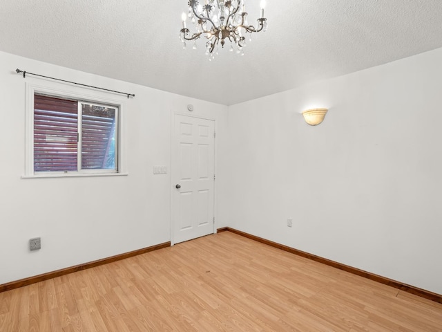 3110 N Del Mar Ave, Fresno, CA 93704 - spare room with light wood finished floors, a chandelier, and a textured ceiling