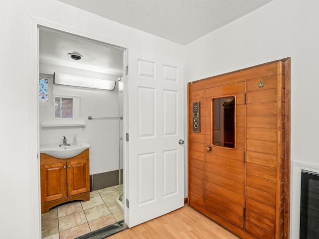 3110 N Del Mar Ave, Fresno, CA 93704 - bathroom with vanity, wood finished floors, and a textured ceiling