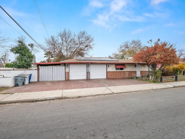 3110 N Del Mar Ave, Fresno, CA 93704 - view of front of home featuring a garage, roof mounted solar panels, concrete driveway, and brick siding