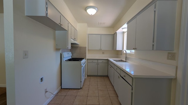 1405 N Lake St, Madera, CA 93638 - kitchen with white gas range oven, under cabinet range hood, light countertops, decorative backsplash, and light tile patterned floors
