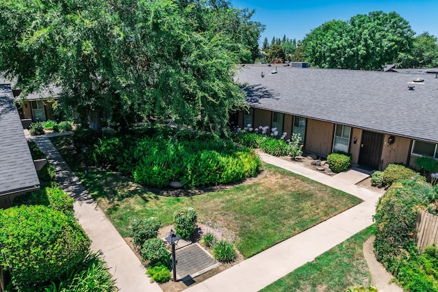 4909 N 7th St Unit S, Fresno, CA 93726 - view of front of home with a shingled roof and a front yard