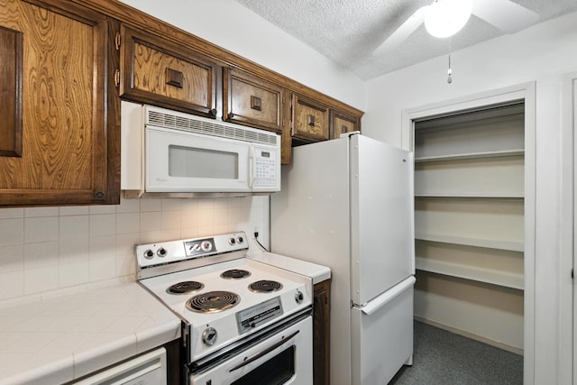 4909 N 7th St Unit S, Fresno, CA 93726 - kitchen featuring white appliances, tile countertops, backsplash, ceiling fan, and a textured ceiling
