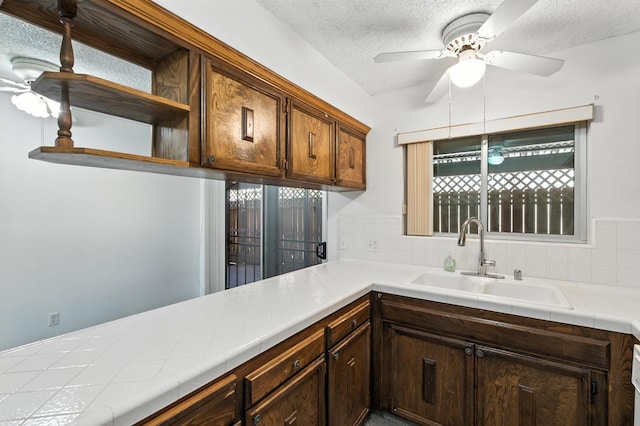 4909 N 7th St Unit S, Fresno, CA 93726 - kitchen with tile counters, a ceiling fan, a textured ceiling, decorative backsplash, and open shelves