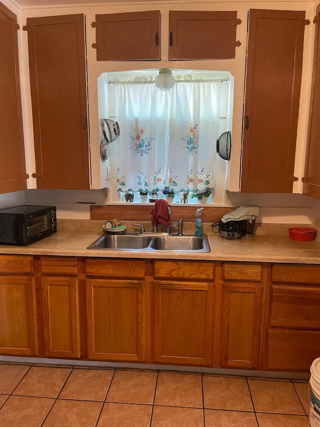 826 N W St, Visalia, CA 93291 - kitchen featuring light tile patterned floors, light countertops, and brown cabinetry