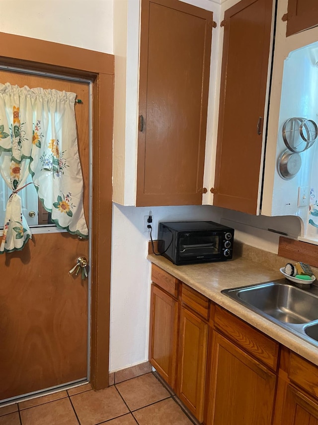 826 N W St, Visalia, CA 93291 - kitchen with light tile patterned floors, brown cabinetry, and light countertops