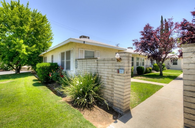 740 E Cornell Ave, Fresno, CA 93704 - view of side of home featuring a yard and stucco siding