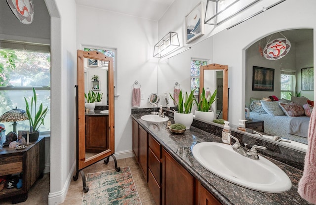 2148 N Ivanhoe Ave, Fresno, CA 93722 - ensuite bathroom featuring double vanity, plenty of natural light, and tile patterned floors