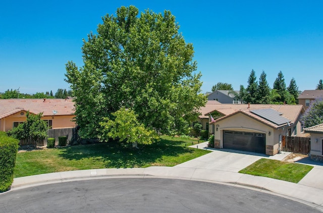 2148 N Ivanhoe Ave, Fresno, CA 93722 - view of front of property featuring stucco siding, a tiled roof, roof mounted solar panels, an attached garage, and concrete driveway