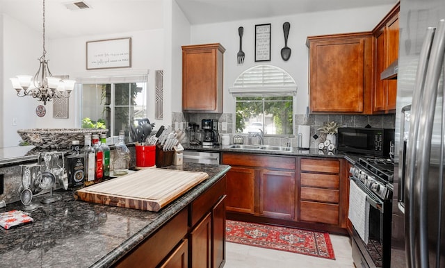 2148 N Ivanhoe Ave, Fresno, CA 93722 - kitchen with stainless steel appliances, backsplash, a chandelier, and dark stone counters