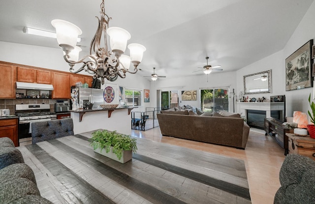 2148 N Ivanhoe Ave, Fresno, CA 93722 - living room with a chandelier, light wood finished floors, ceiling fan, and a glass covered fireplace