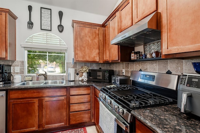 2148 N Ivanhoe Ave, Fresno, CA 93722 - kitchen with appliances with stainless steel finishes, under cabinet range hood, tasteful backsplash, brown cabinets, and dark stone countertops