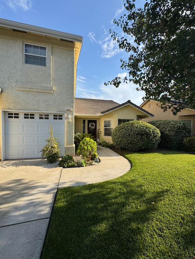 605 W Russell Ave, Visalia, CA 93277 - view of front of property with a garage, stucco siding, concrete driveway, and a front lawn