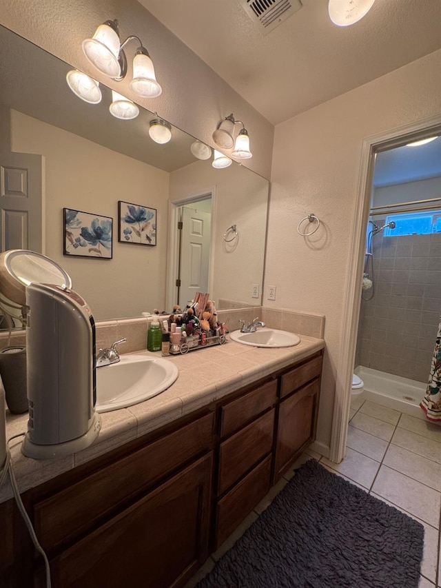 605 W Russell Ave, Visalia, CA 93277 - full bath with tiled shower, double vanity, and tile patterned floors