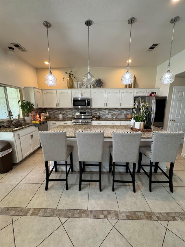 605 W Russell Ave, Visalia, CA 93277 - kitchen featuring stainless steel appliances, backsplash, and a kitchen bar