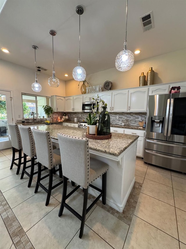 605 W Russell Ave, Visalia, CA 93277 - kitchen with appliances with stainless steel finishes, backsplash, white cabinets, light stone countertops, and recessed lighting