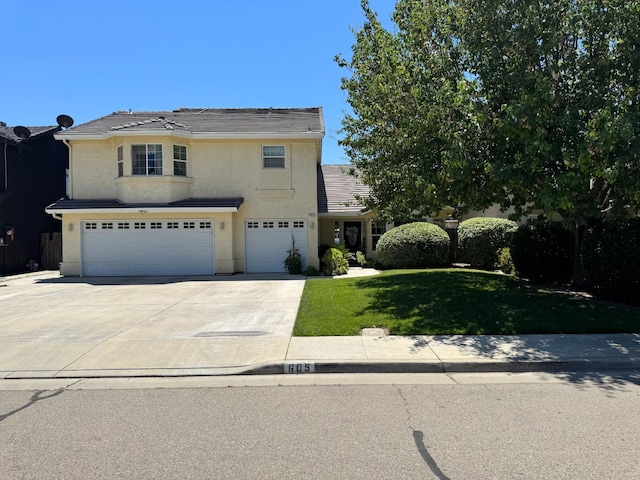 605 W Russell Ave, Visalia, CA 93277 - traditional-style home featuring a garage, driveway, a front yard, and stucco siding