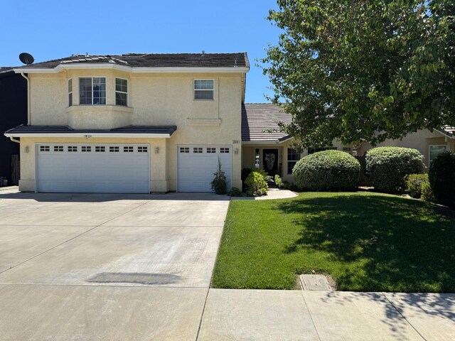 605 W Russell Ave, Visalia, CA 93277 - traditional-style home featuring an attached garage, concrete driveway, stucco siding, and a front lawn