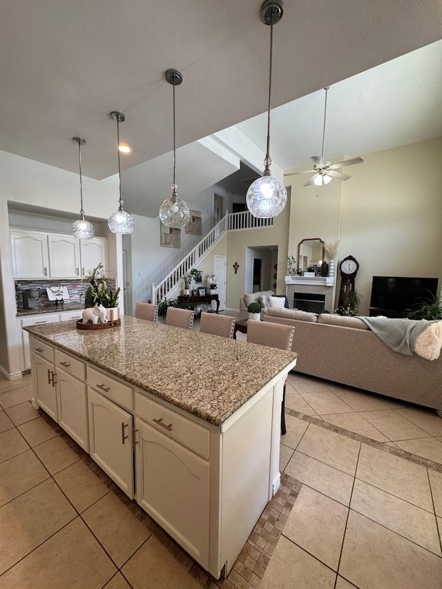 605 W Russell Ave, Visalia, CA 93277 - kitchen featuring light tile patterned flooring, a ceiling fan, white cabinets, and pendant lighting