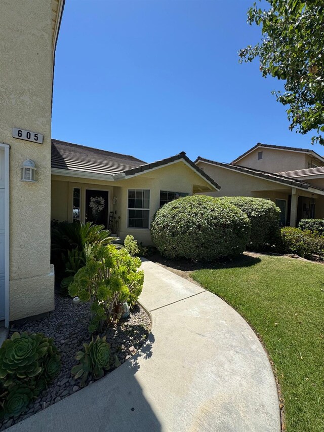 605 W Russell Ave, Visalia, CA 93277 - doorway to property featuring stucco siding and a yard