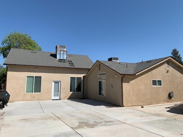 back of house with stucco siding, a patio, and a shingled roof