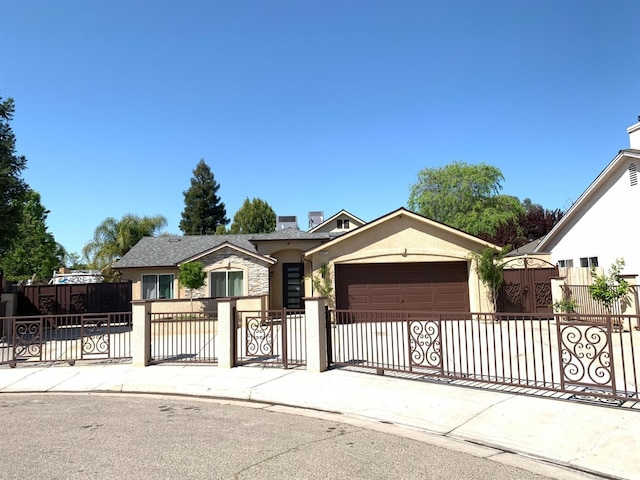 ranch-style house with an attached garage, stucco siding, a fenced front yard, and a gate