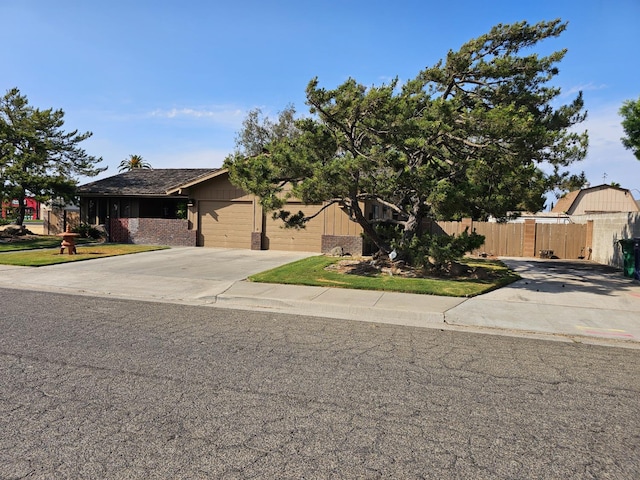 1 Adams Dr, Chowchilla, CA 93610 - obstructed view of property featuring concrete driveway, brick siding, and a garage