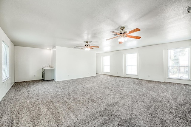 1224 Oak Ave, Clovis, CA 93611 - unfurnished living room featuring a textured ceiling, carpet flooring, and ceiling fan