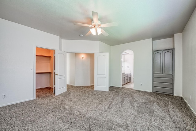 1224 Oak Ave, Clovis, CA 93611 - unfurnished bedroom with carpet, arched walkways, a walk in closet, ensuite bathroom, and a ceiling fan