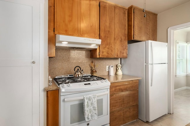 920 W 6th St, Madera, CA 93637 - kitchen featuring white appliances, under cabinet range hood, brown cabinetry, decorative backsplash, and light tile patterned flooring