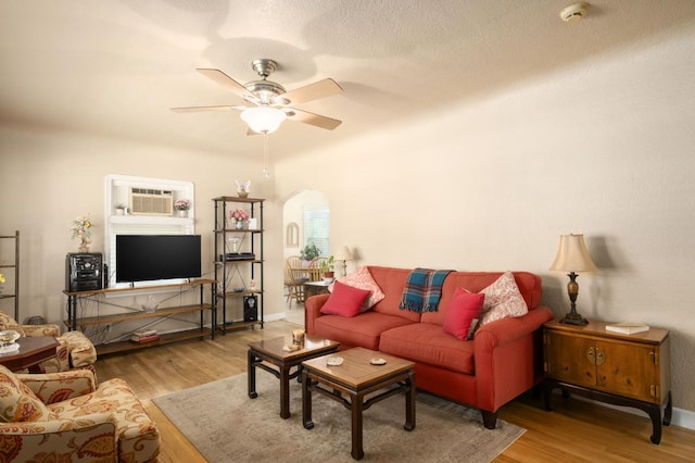 920 W 6th St, Madera, CA 93637 - living area with arched walkways, wood finished floors, a ceiling fan, and a wall mounted air conditioner