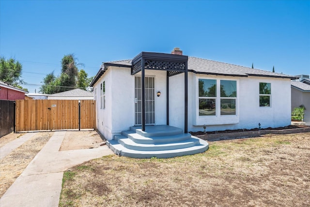 2012 E Clinton Ave, Fresno, CA 93703 - bungalow-style house with a gate, stucco siding, a chimney, and a shingled roof