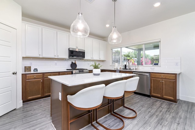 165 Timberline Way S, Madera, CA 93636 - kitchen featuring stainless steel appliances, decorative backsplash, light countertops, white cabinets, and light wood-type flooring