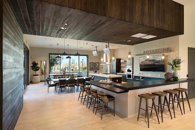 165 Timberline Way S, Madera, CA 93636 - kitchen with a breakfast bar, a kitchen island, double oven, decorative light fixtures, and wood ceiling